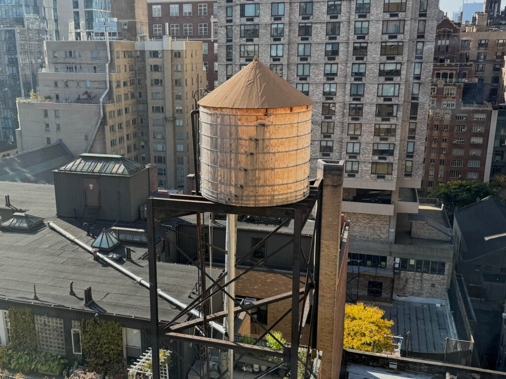 Wooden water tank elevated over a roof of a residential building