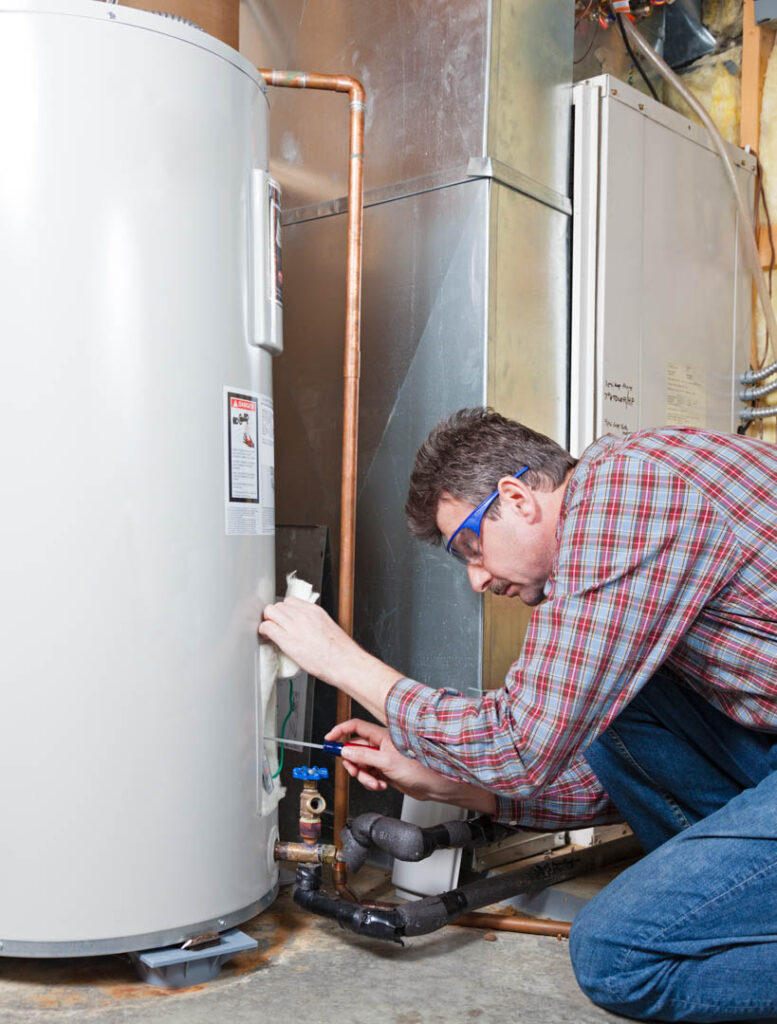 A plumber is performing maintenance on a residential water heater