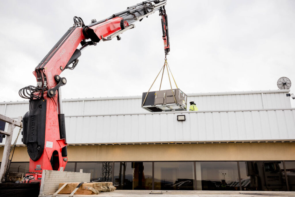 RTU unit being craned to the roof by professionals
